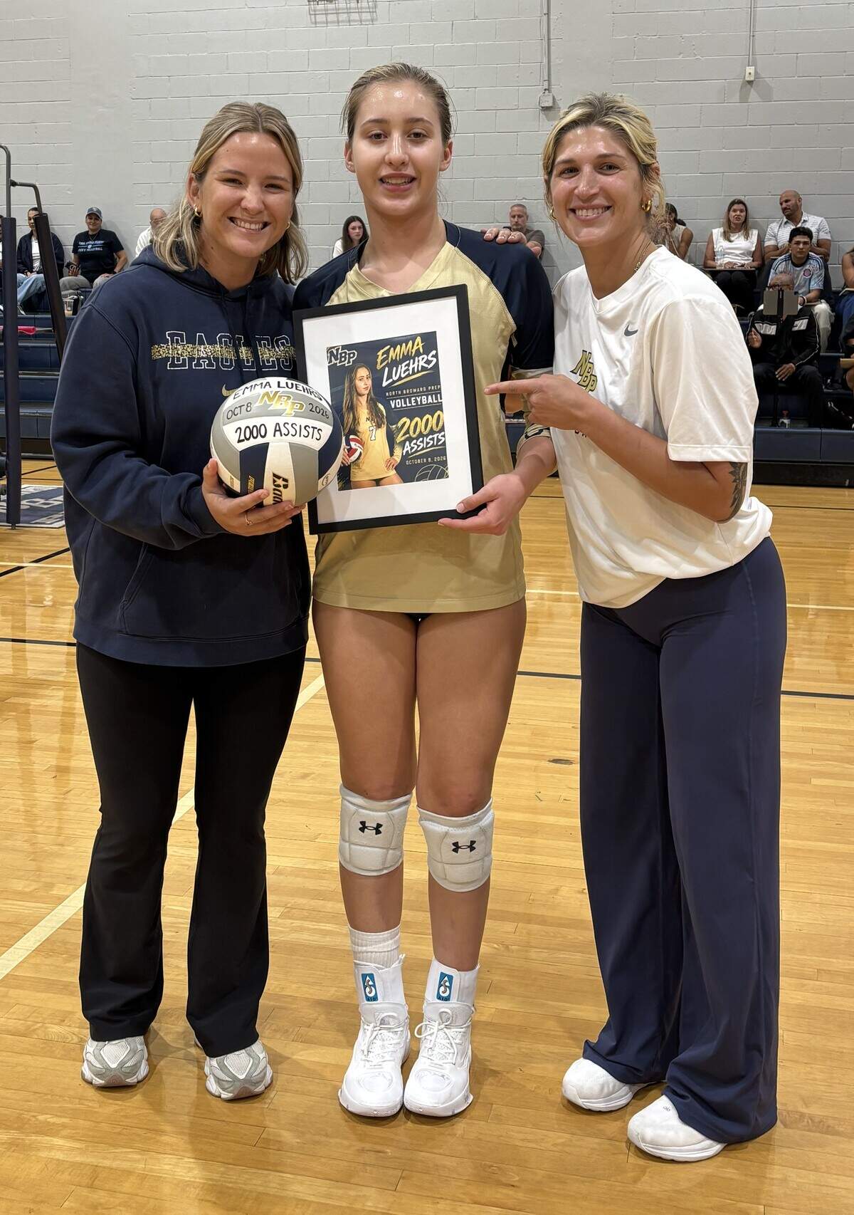 Before the district semifinal, North Broward Prep freshman setter Emma Luehrs was honored for reaching a milestone mark. Also pictured are Assistant Coach Grace Staudt (left) and Heach Coach Chelsey Tekavec (right).